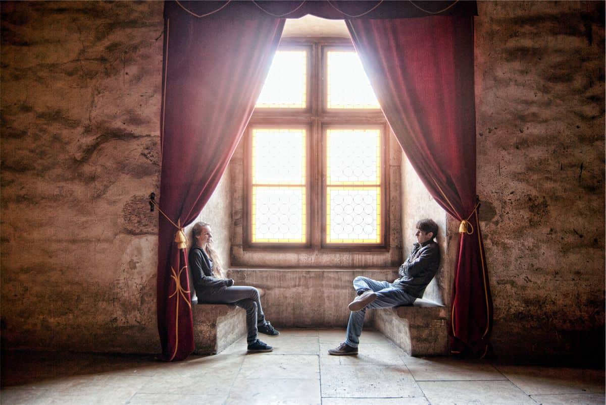 Two people sitting by the window facing each other in conversation. When designing with a content-first approach, think of design as a conversation with your users.
