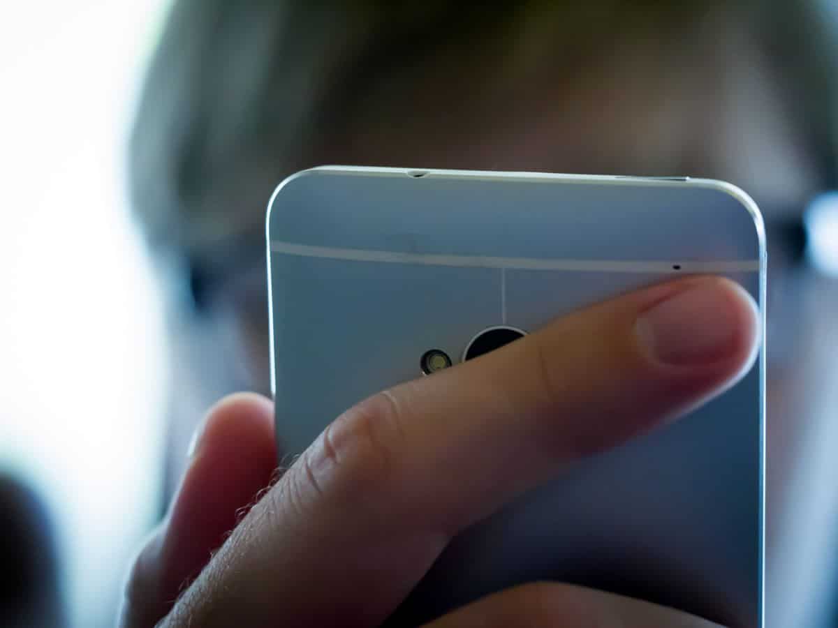 A close up on a mobile user holding an iPhone. Switch from web to mobile app design requires special attention to ergonomics and the way users interact with their devices.