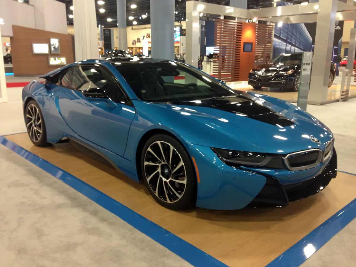 A gleaming blue BMW i8 parked in a showroom.