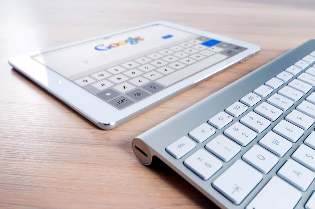 An iPad displaying Google.com search and an Apple keyboard. Writing a great app description involves SEO and keywords.