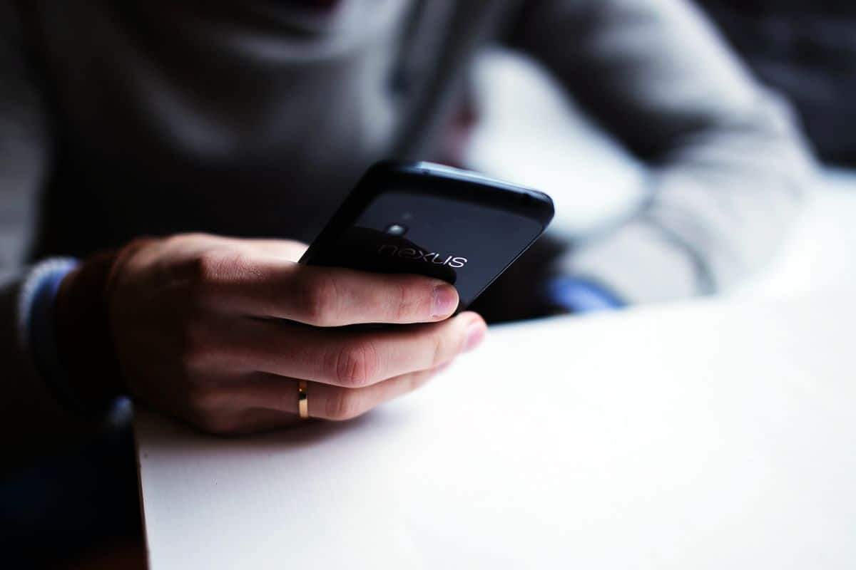 A close-up on a man’s hand holding an Android smartphone.