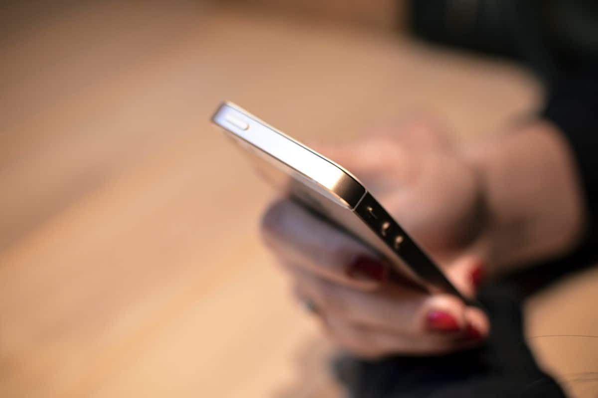 A close-up of a woman’s hand testing an app on her smartphone.