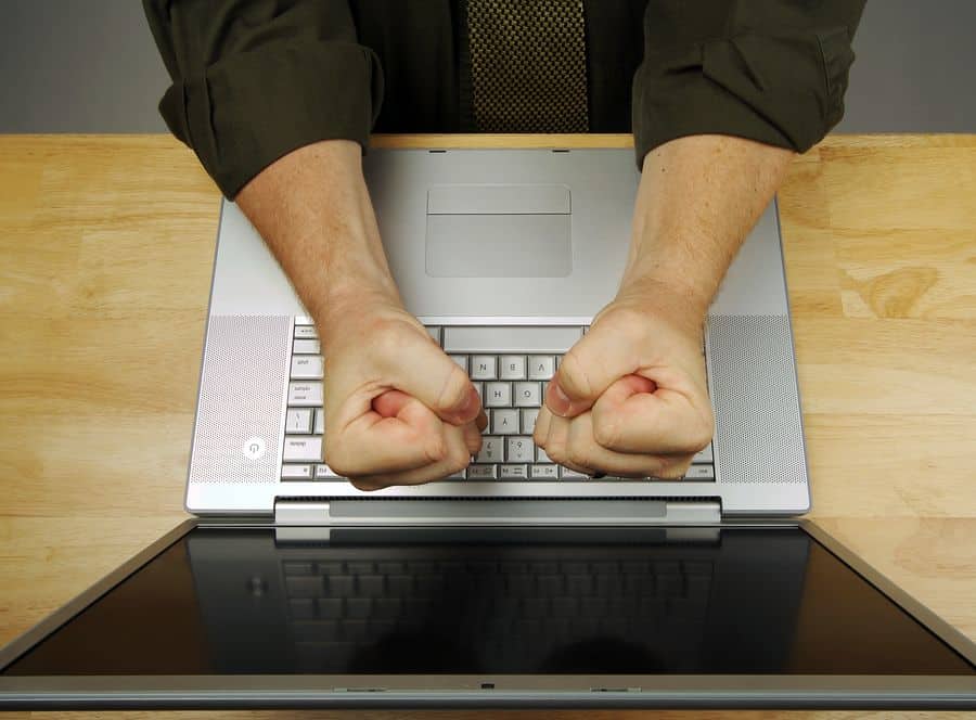 A UX visual designer slams her fists down on the keyboard of her laptop.