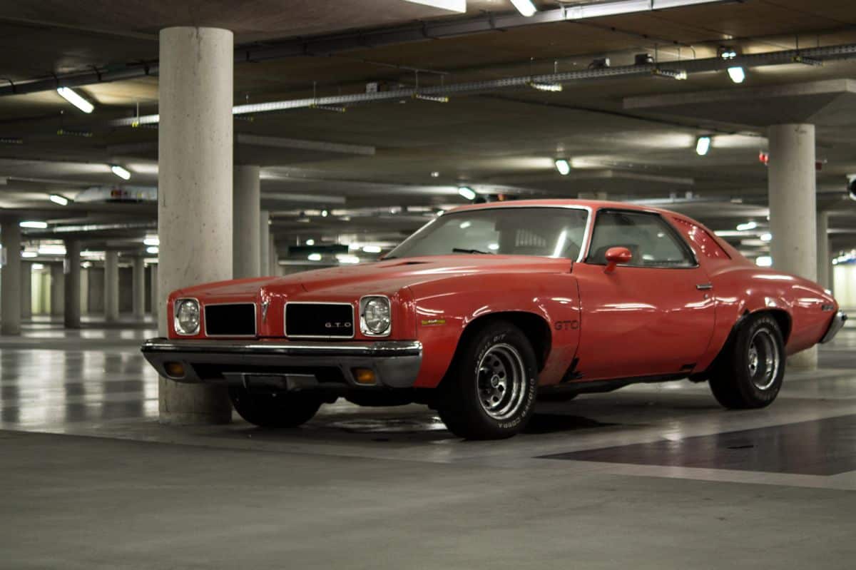 An American vintage car parked in an empty parking lot.