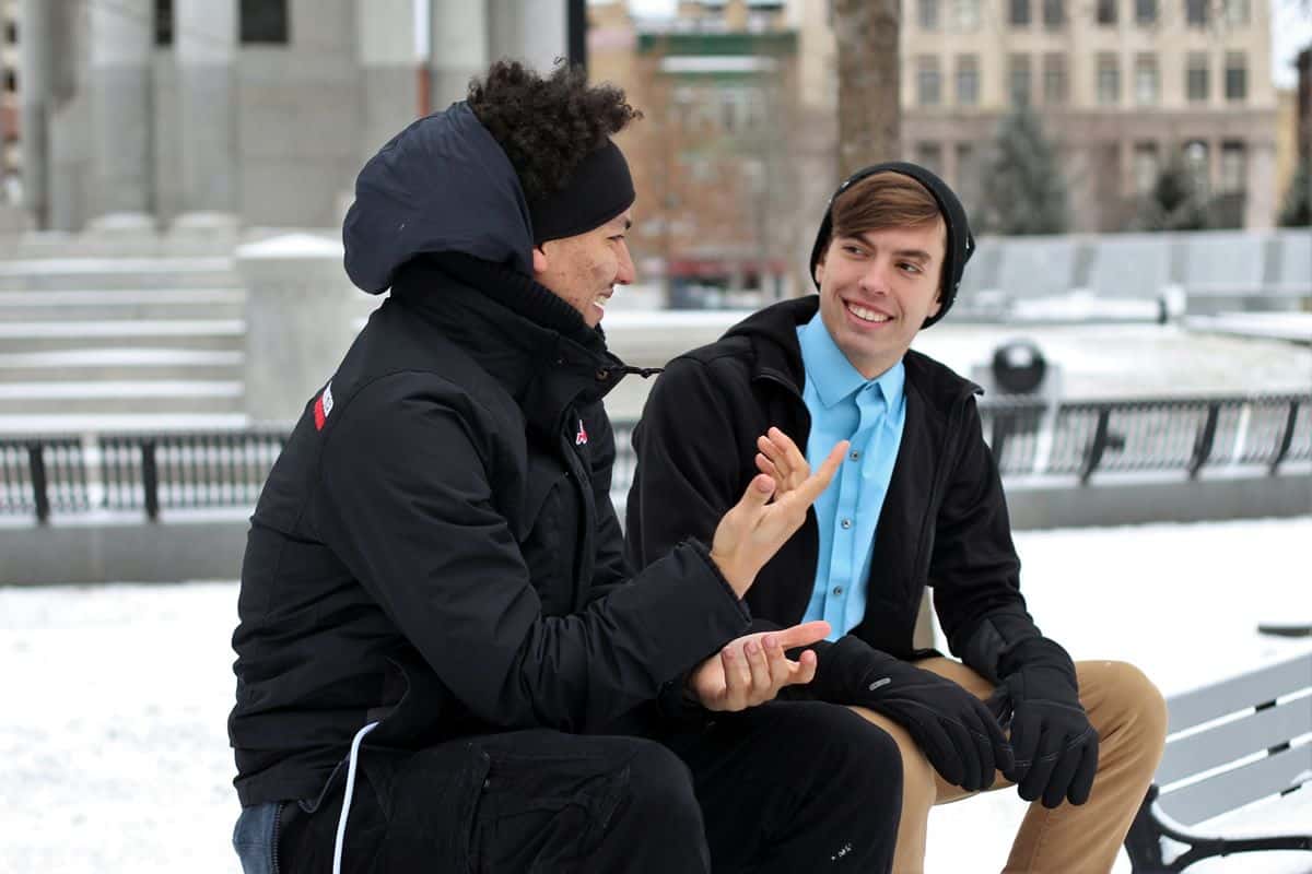 Two young men having a conversation outside in winter. Being responsive and treating the user interviews as conversations help to get the data you need.
