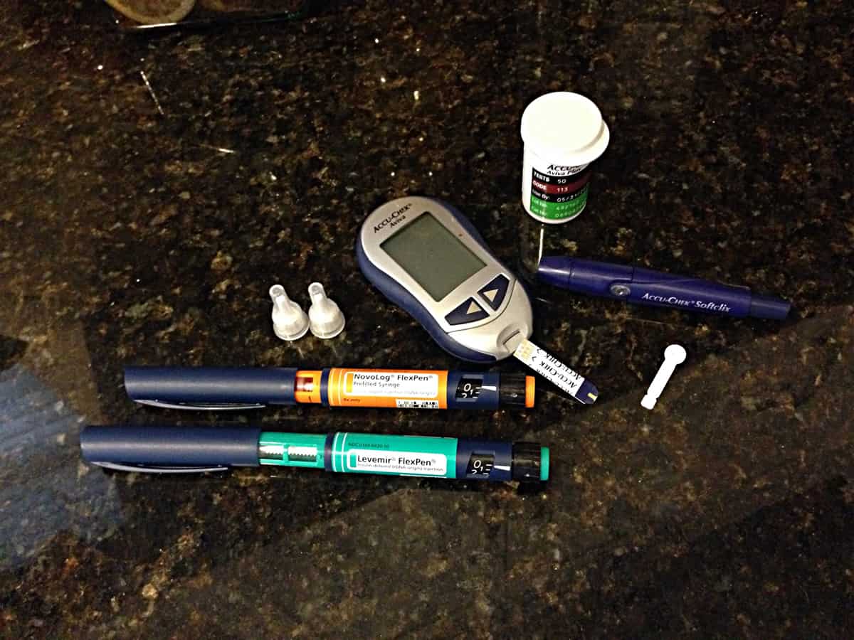 A photo of diabetes testing supplies on a granite countertop.