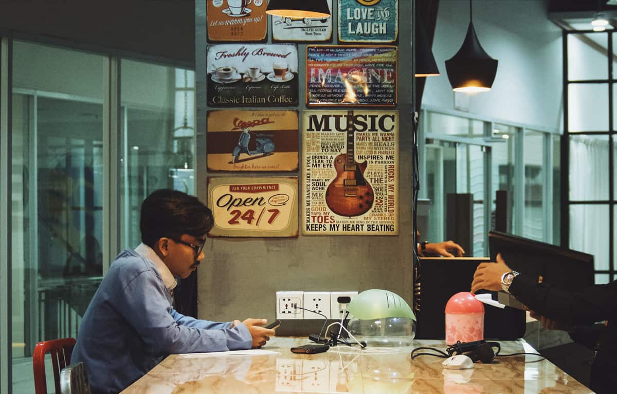 A photo of a man working alone in a coffee shop.