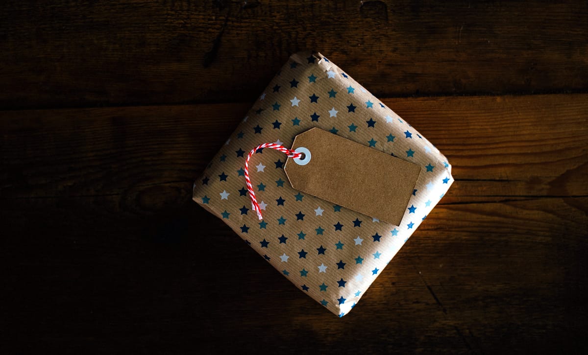 A gift wrapped with star-patterned parcel papel with an empty gift tag.
