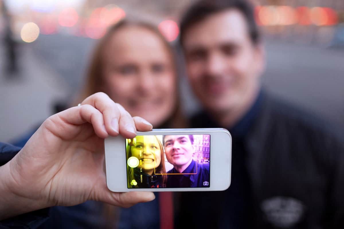 A photo of a couple taking a selfie using the Instagram app on an iPhone.