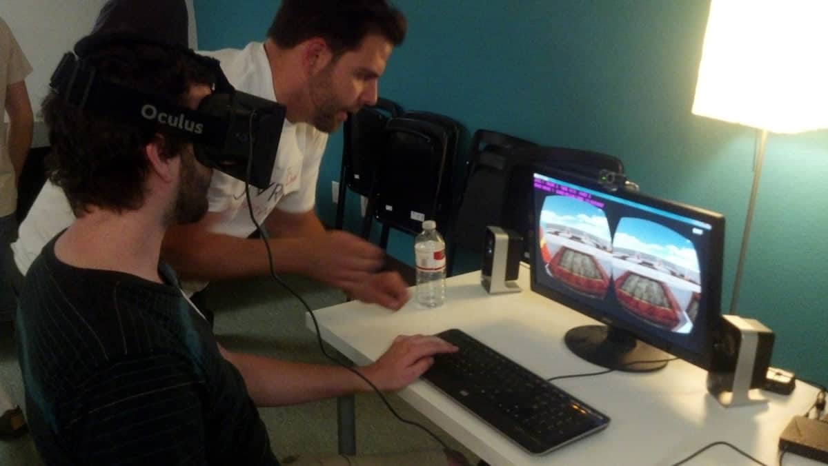 A photo of a man using an Oculus Rift virtual reality headset while his friend looks on.