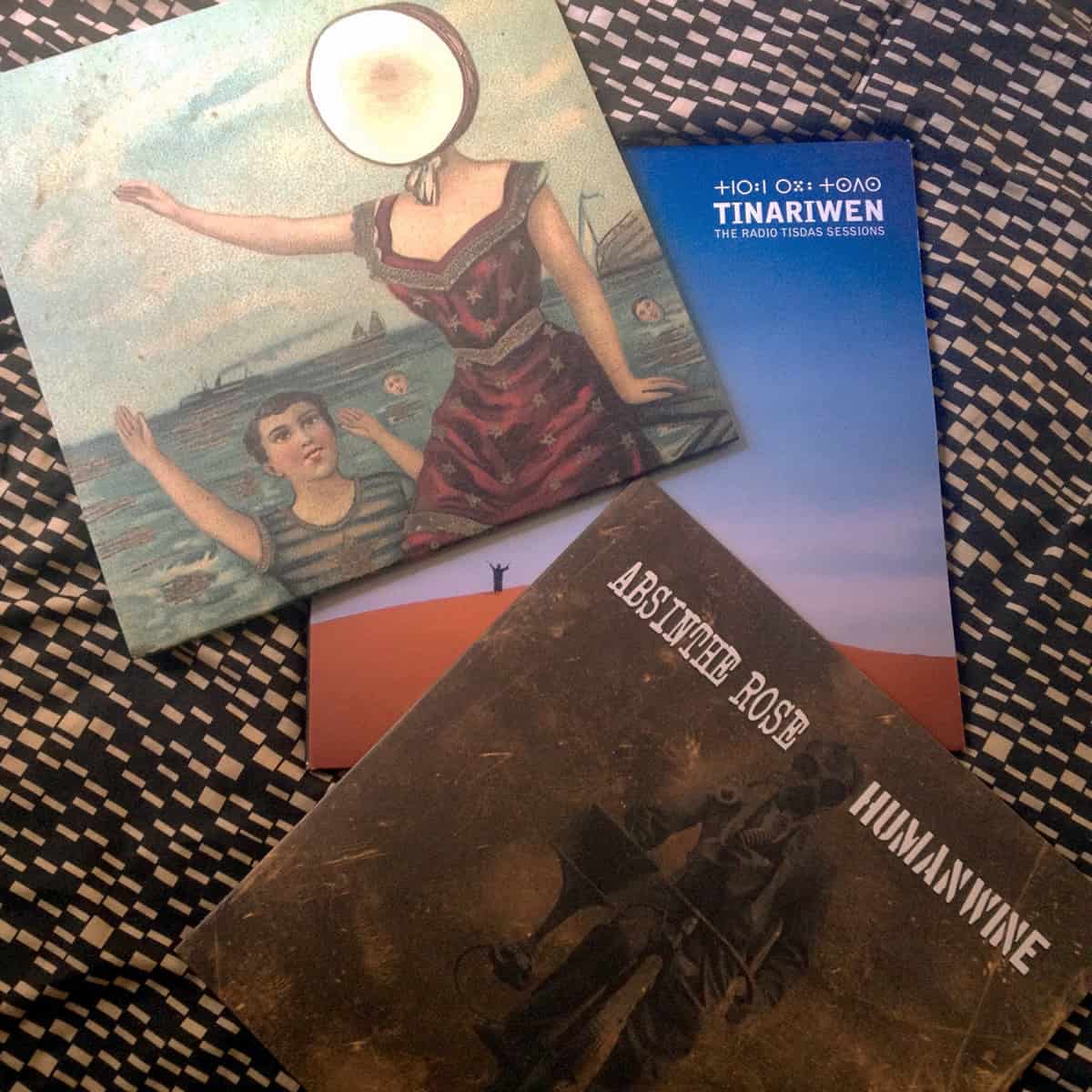 A photo of three vinyl albums, including In the Aeroplane Over the Sea by Neutral Milk Hotel and Humanwine by Absinthe Rose.