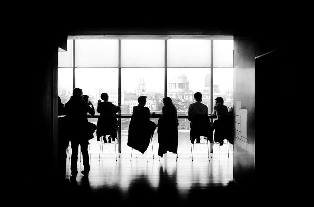 A photo of a people sitting and talking in a window.