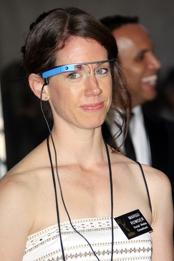 A picture of a woman wearing an early version of Google Glass in blue.