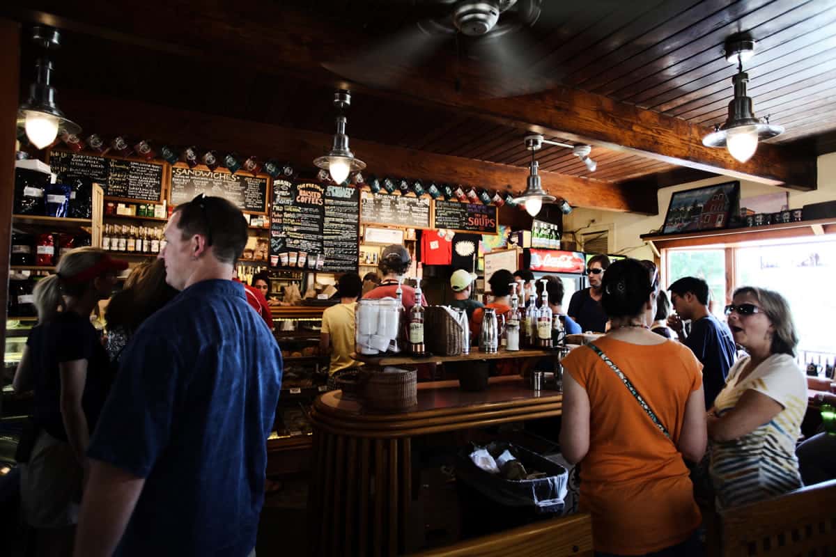 Image of people waiting in line and talking to each other in a coffee shop.