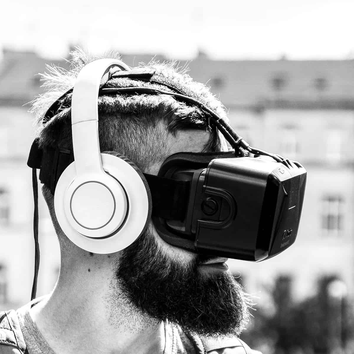 A photo of a man wearing headphones and a virtual reality head-mounted display.