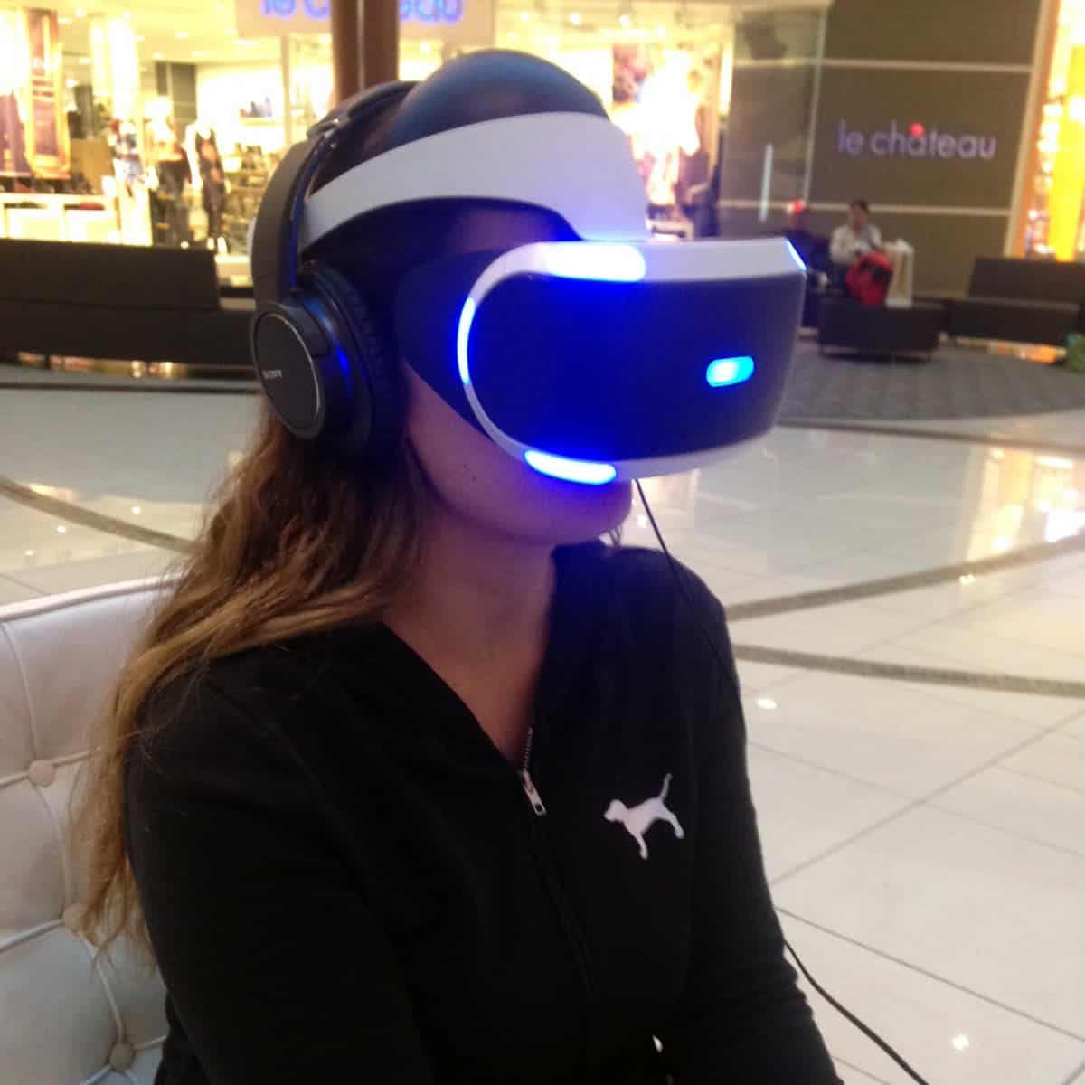 A photo of a woman wearing a virtual reality headset in a shopping mall.