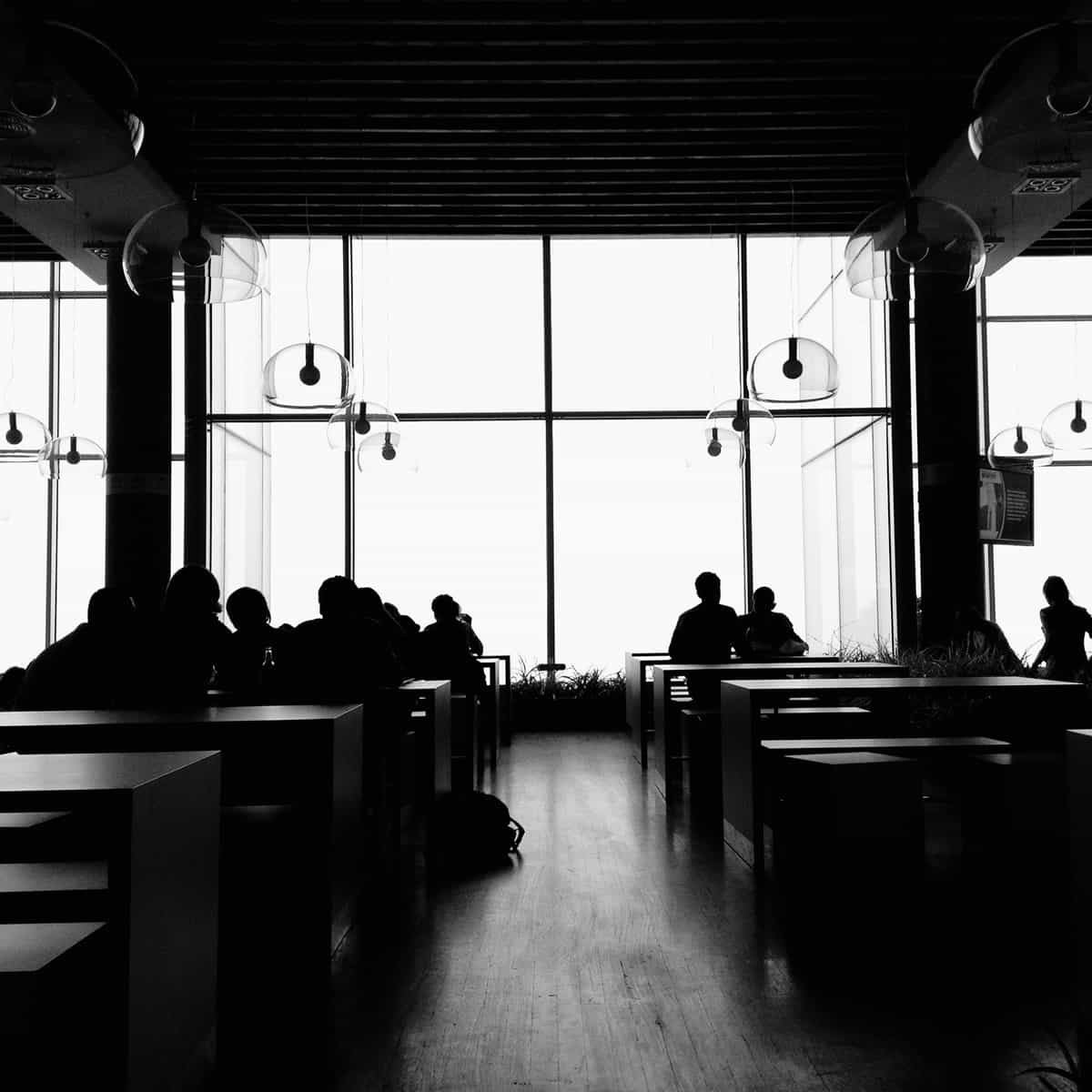 Image of people sitting on benches around tables.