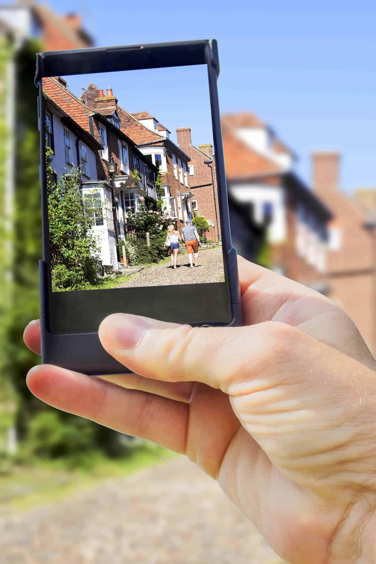 A photo of someone using a mobile device to take a picture of two people walking.