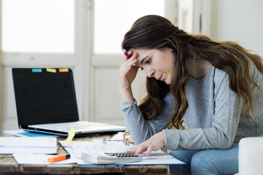 A photo of a frustrated woman trying to balance her business books.