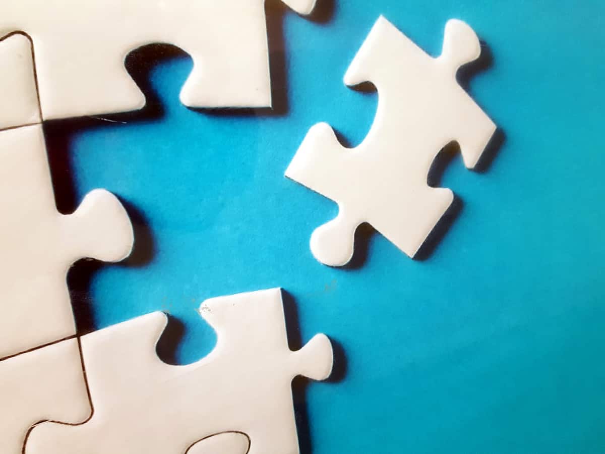 A close-up photo of five puzzle pieces together and one ready to be placed.