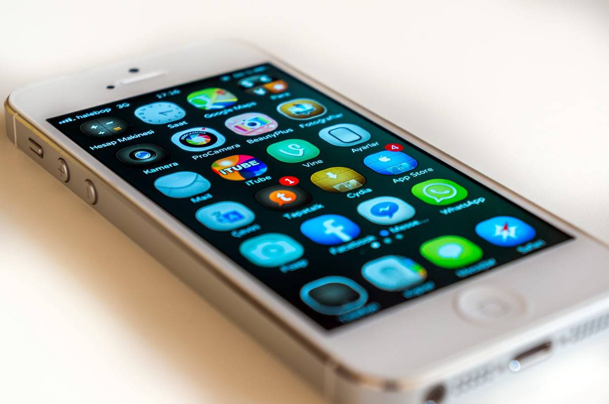 A photo of an iPhone screen with multiple mobile app icons displayed.