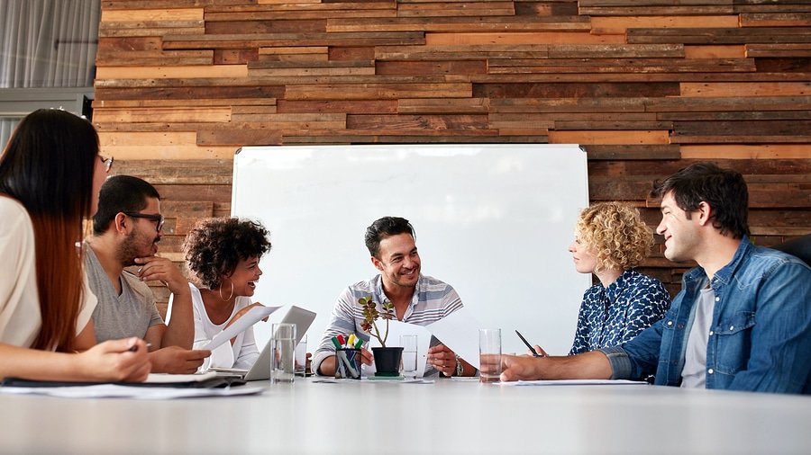 A photo of a team of happy people in a meeting.