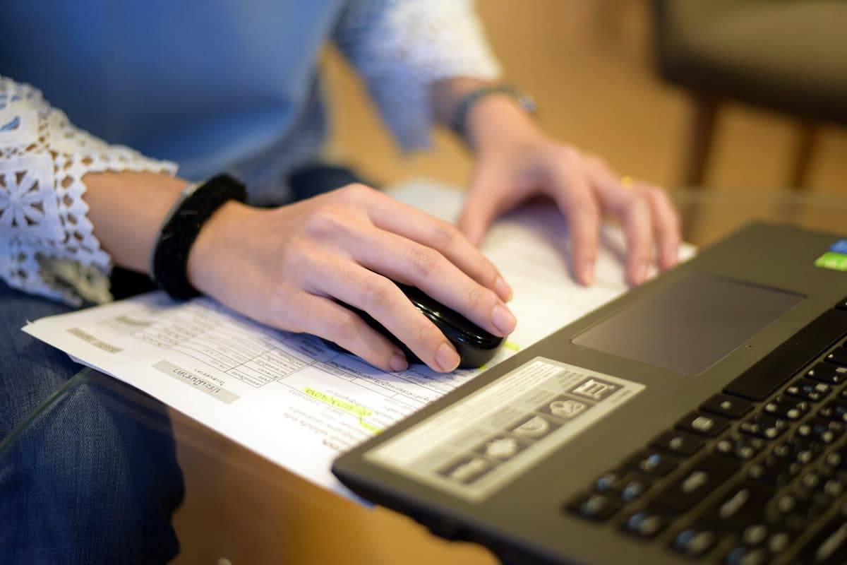 A photo of a person using paper as a mousepad while using a computer.