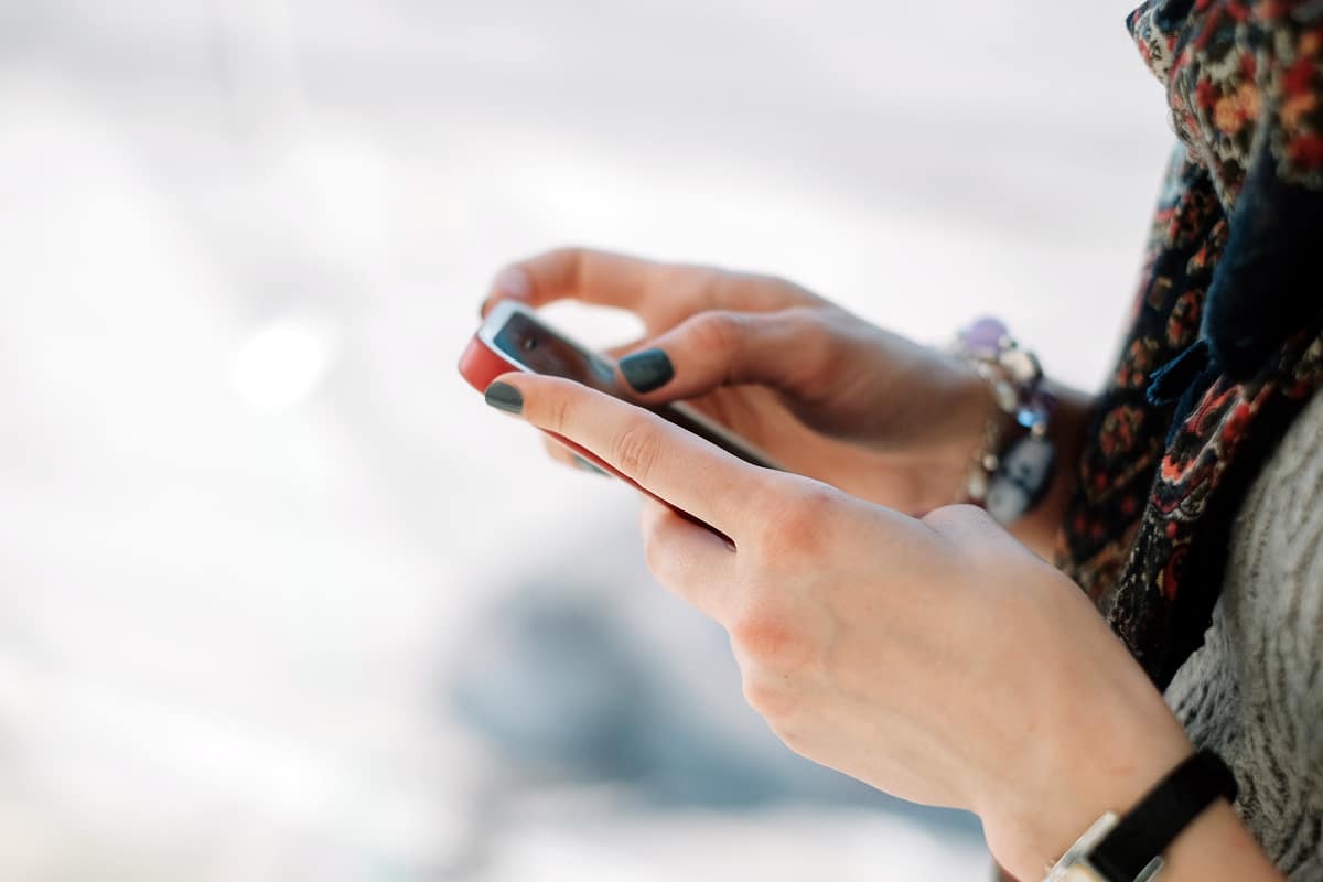 A photo of a woman reading something on her mobile device.