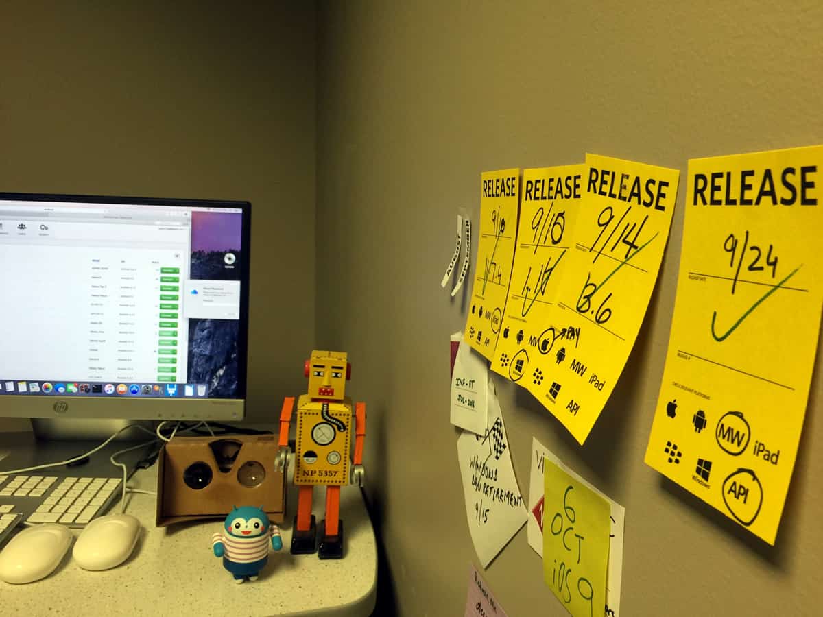 A photo of a person’s office with multiple sticky notes hanging on the wall.