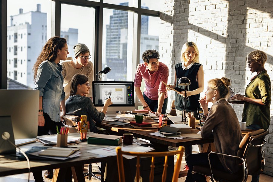 A photo of a work group discussing mobile app ideas in an office.