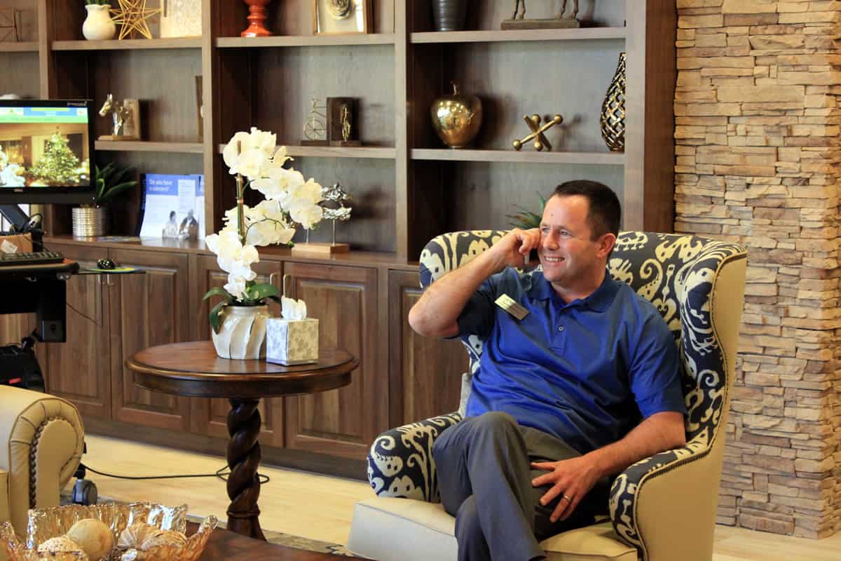 A photo of a business man taking a call on his cell phone in a waiting room.