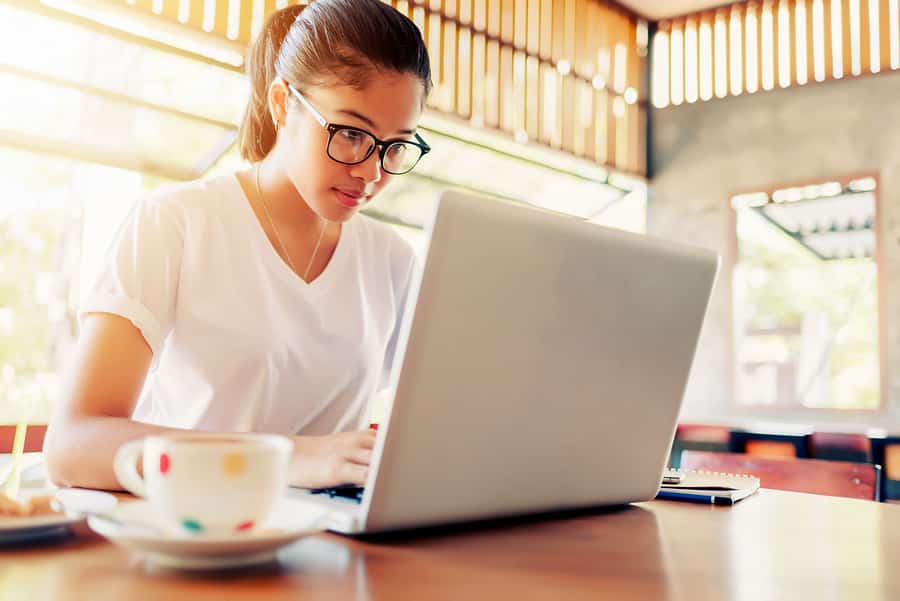 A photo of a female entrepreneur working in a coffee shop.