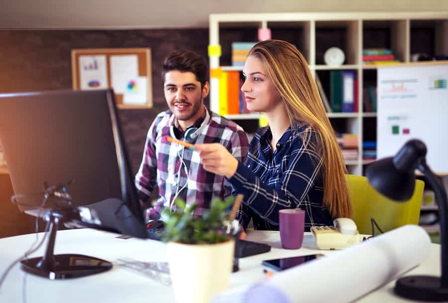 A photo of two coworkers discussing a new mobile app design in the office.