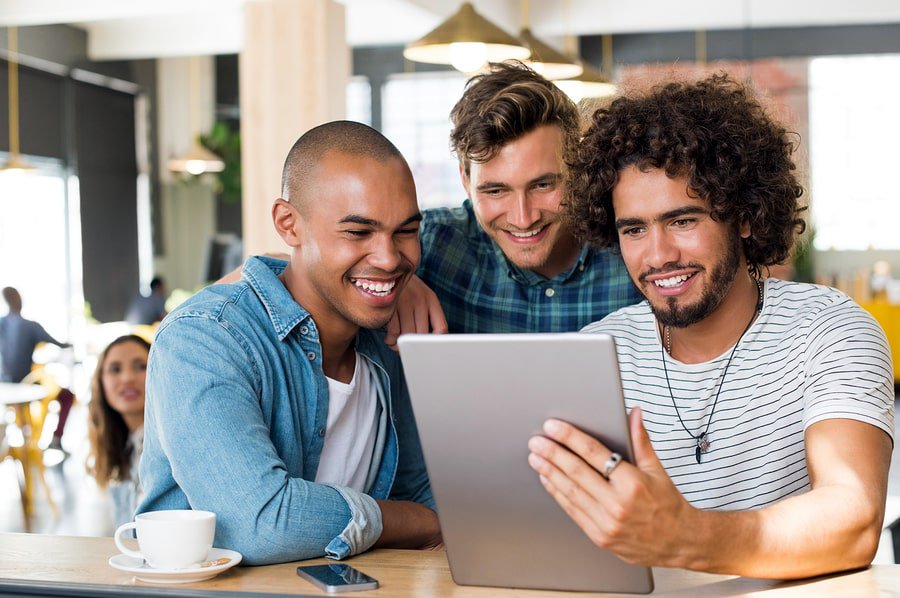 A photo of three men looking at a new mobile game design on a tablet.