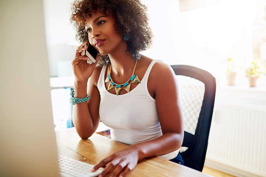 A photo of an inspiring female entrepreneur taking a call during her workday.