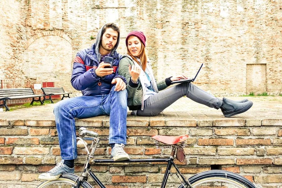 A photo of a man and woman working out their mobile app ux design through a prototype.