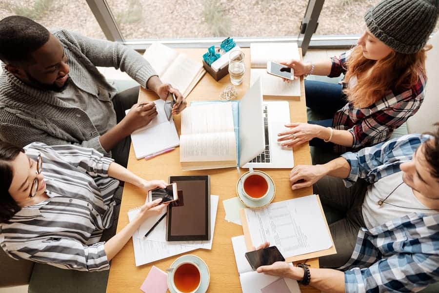 A photo of four millennials meeting to discuss their latest mobile app design.