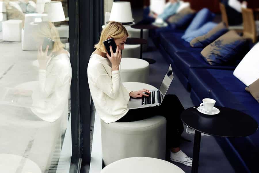 A photo of a woman having a phone meeting in a public cafe.