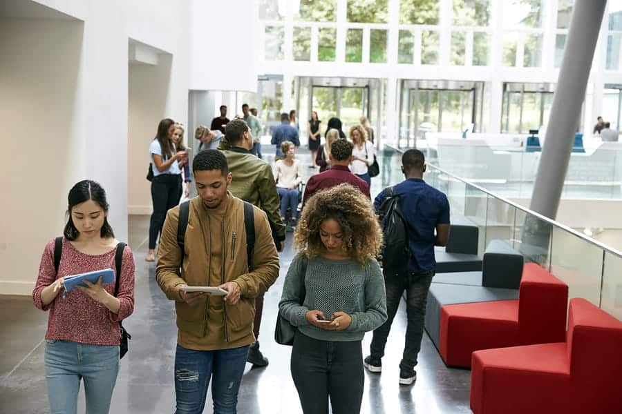 A photo of students making their way through a building, heads buried in their mobile devices.