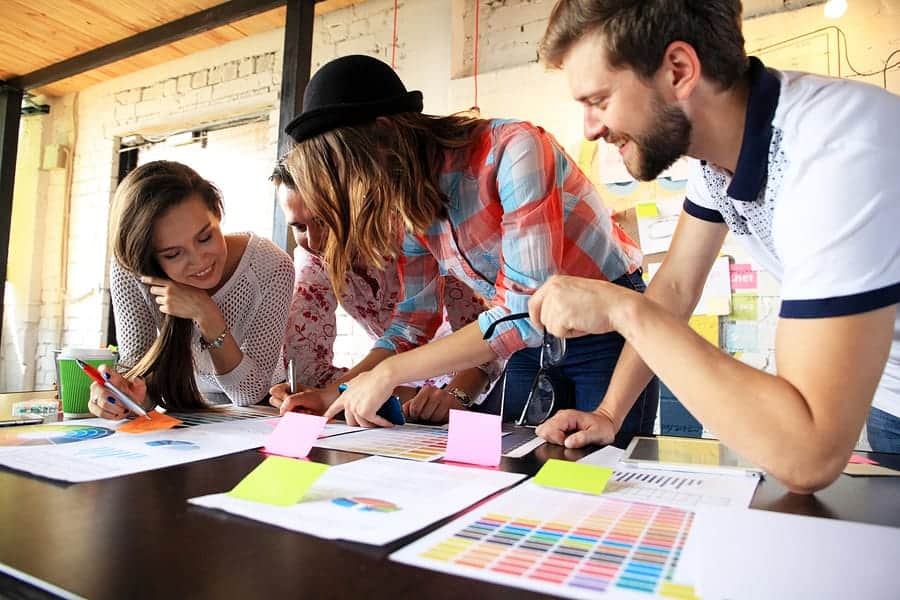 A photo of a design team leaning over color charts.