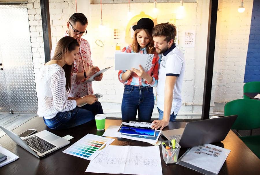 A photo of a work group looking over sketches.