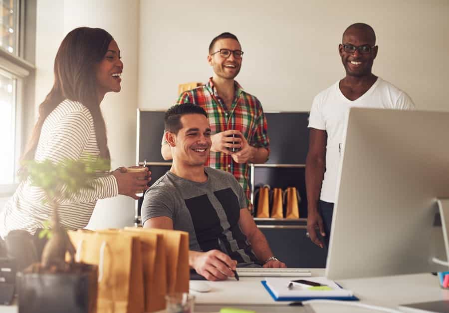 A photo of a work group looking at a new design a computer.