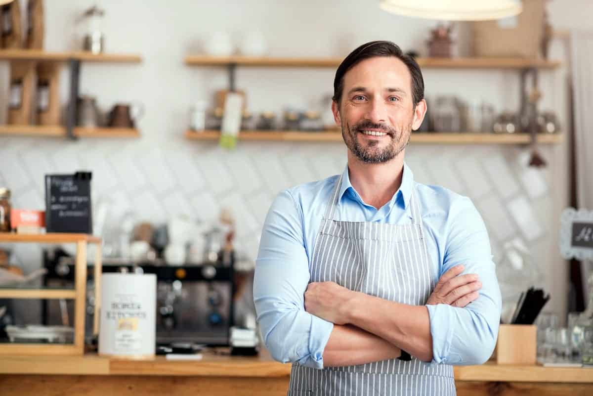 An entrepreneur stands in front of his business.