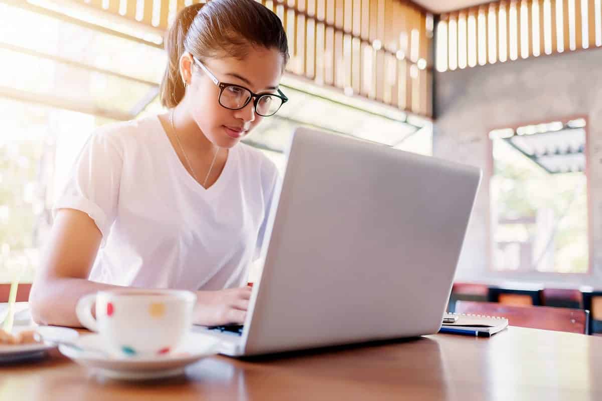 A woman works diligently on her laptop.