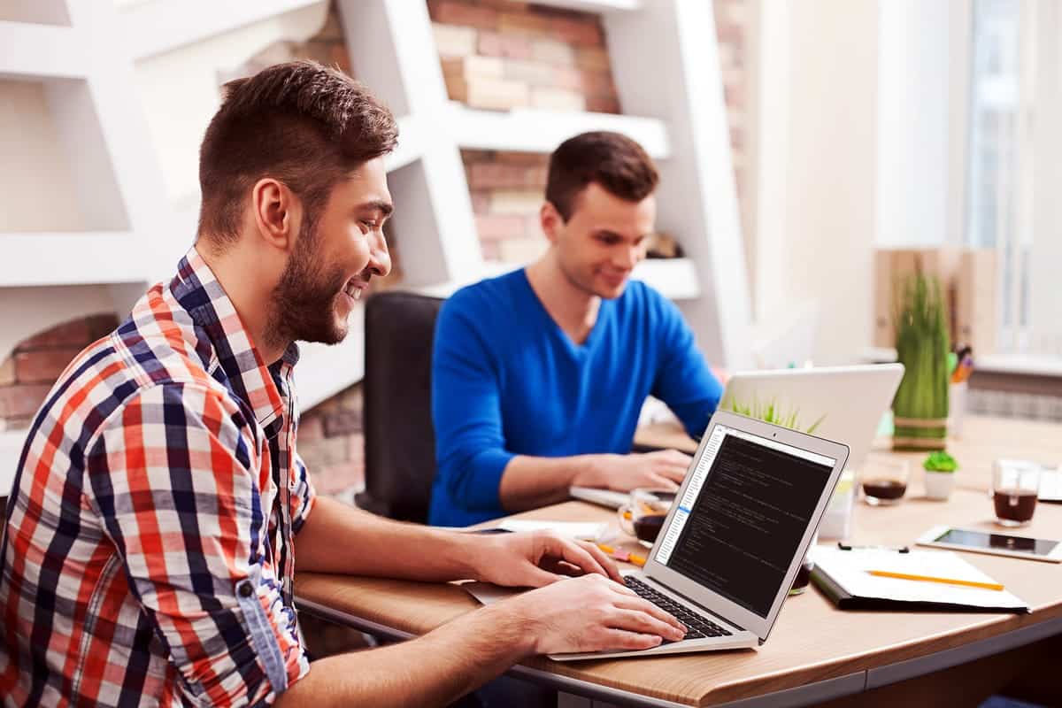 Two men smiling and working.