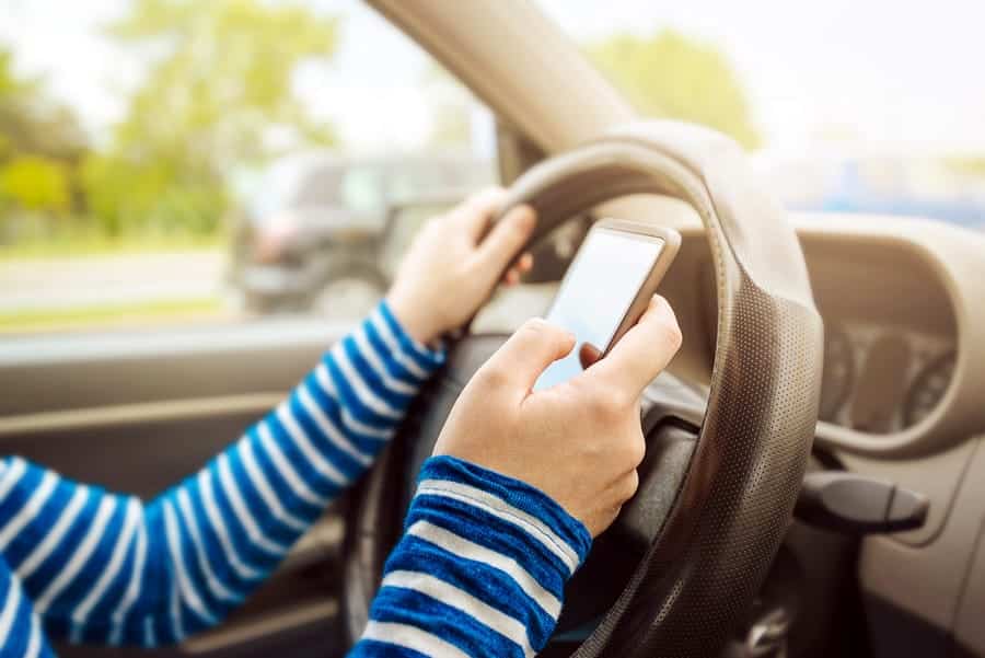 A photo of a person texting while driving.