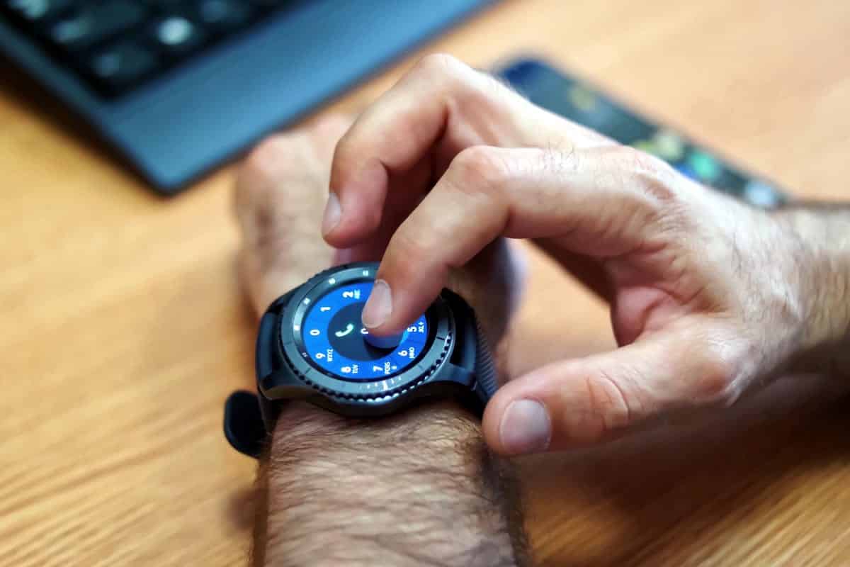 A photo of a man making a phone call on his smartwatch.