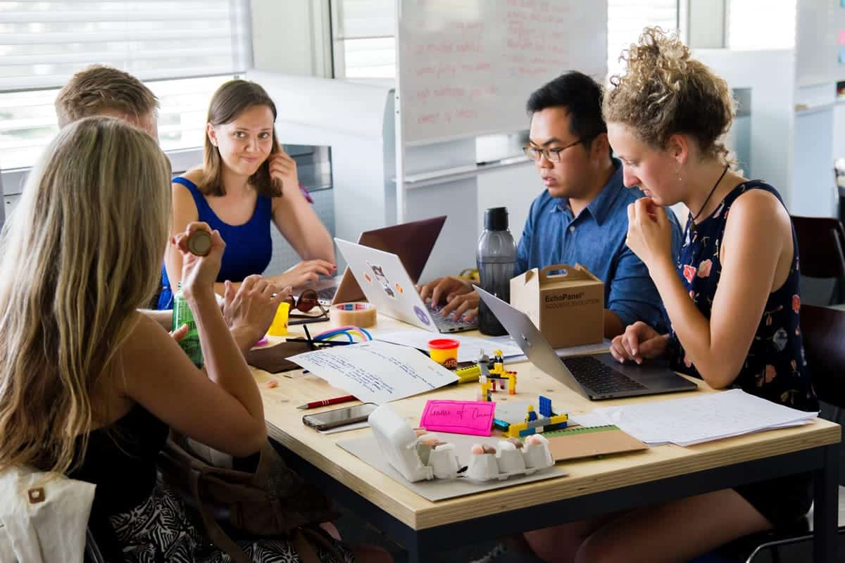 An image of a team sitting around a table during a meeting.