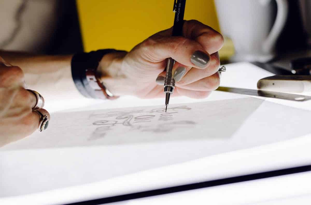 An image of a woman sitting with her team, working on design ideas.