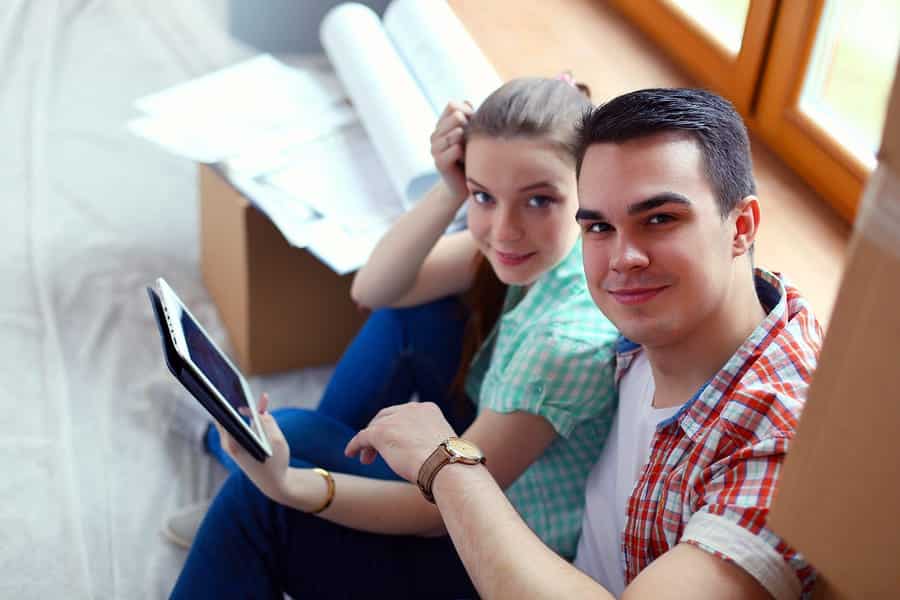 A photo of a couple using their tablet on moving day.